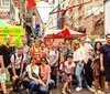A group of people pose for a photo on a lively street with festive decorations