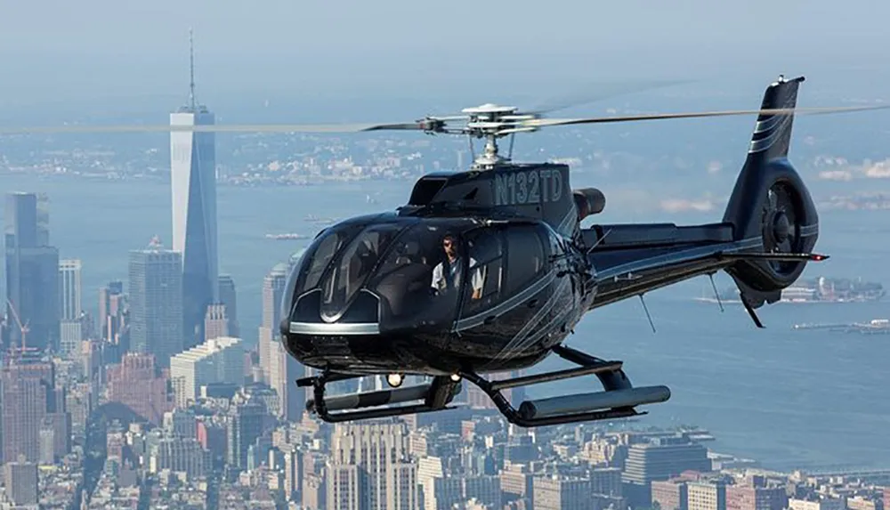 A helicopter flies over a cityscape with a distinct skyscraper in the background
