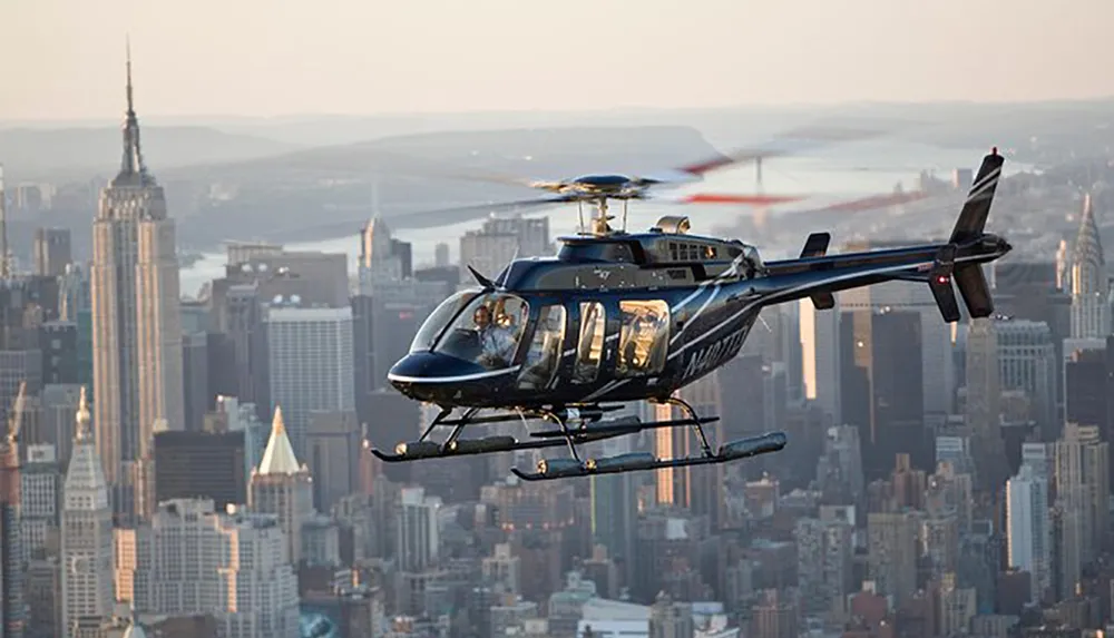 A helicopter flies over an urban landscape with skyscrapers during what appears to be dawn or dusk
