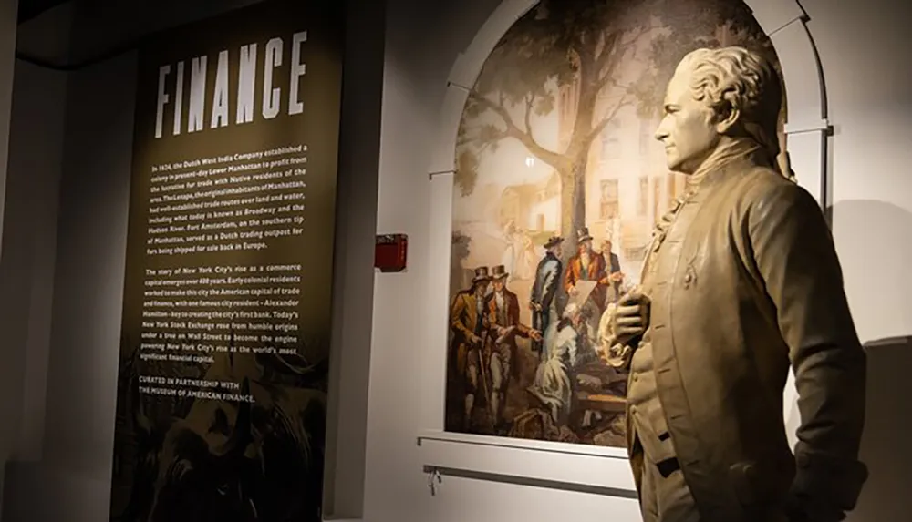The image shows a museum exhibit with a statue of a historical figure next to an informative display discussing the theme of finance with an illustration of historical trade activities in the background