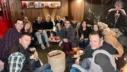 A group of happy people are enjoying drinks together in a cozy lounge with stylish decor.
