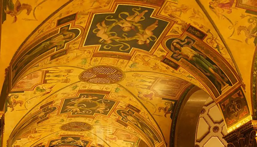 The image shows a richly decorated vaulted ceiling with intricately painted frescoes ornate patterns and gold accents highlighting a sense of opulence and artistry