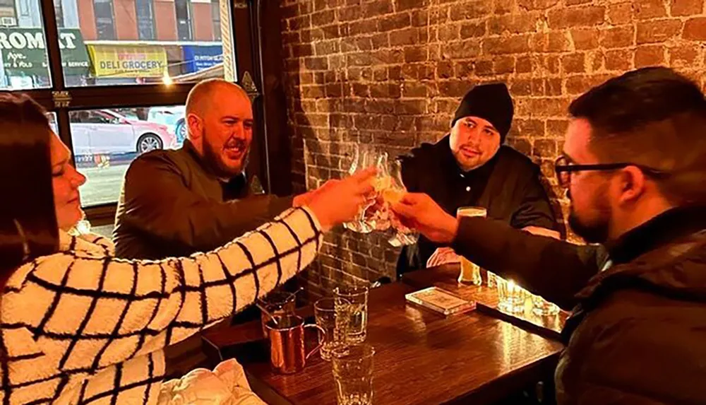 A group of individuals is cheerfully toasting with glasses in a cozy bar setting