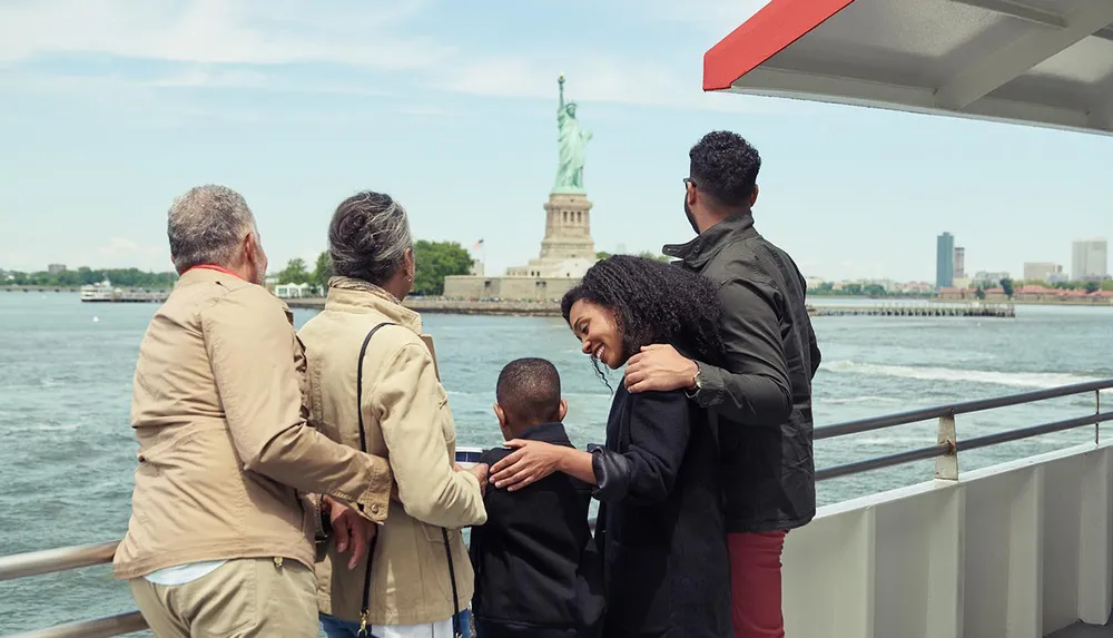 A group of people is enjoying a view of the Statue of Liberty from a boat