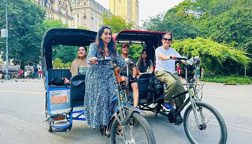 A group of people are enjoying a ride in a pedicab with a smiling cyclist in front set against a background of greenery and classic architecture