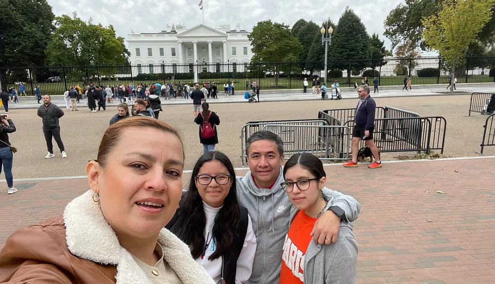 A family is taking a selfie with the White House in the background