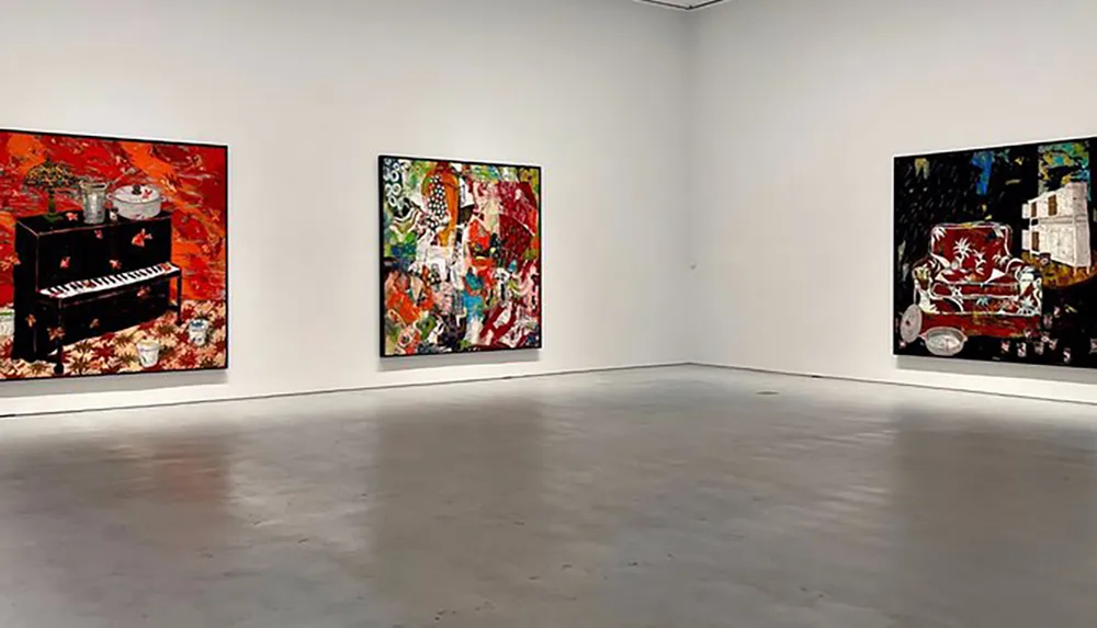 The image shows a modern art gallery room with three large colorful abstract paintings displayed on white walls