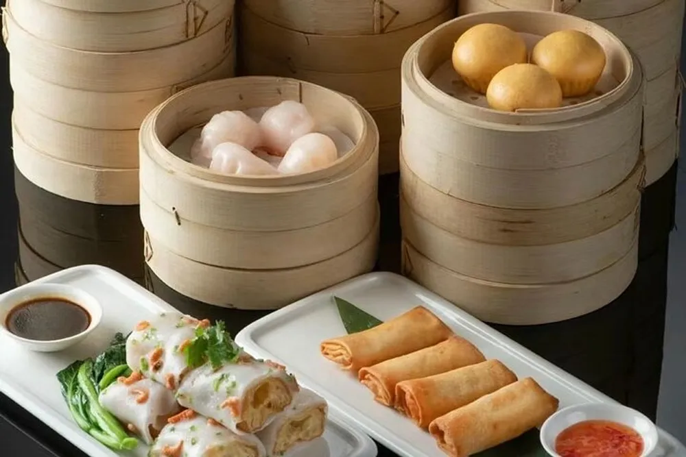 The image shows a variety of traditional Chinese dim sum dishes served in bamboo steamers and on white plates