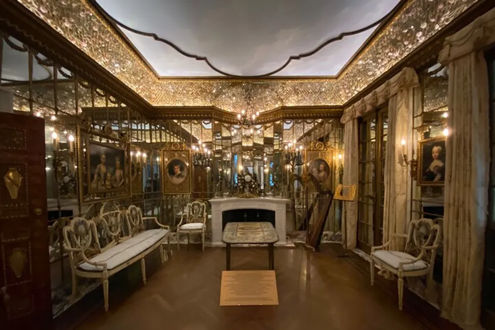 The image features an ornate room with mirrored walls gilded furniture elaborate lighting and paintings conveying a sense of historical luxury