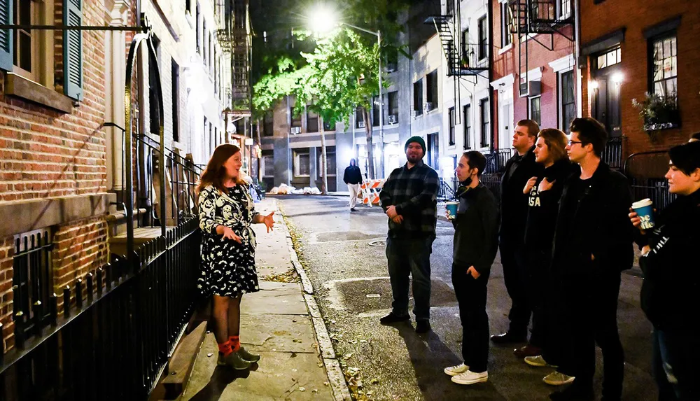 A group of people is engaged in a night-time walking tour in an urban alley with a guide leading the experience