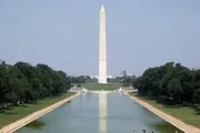 This image features the Washington Monument, a towering obelisk, overlooking the Reflecting Pool in the National Mall in Washington, D.C.