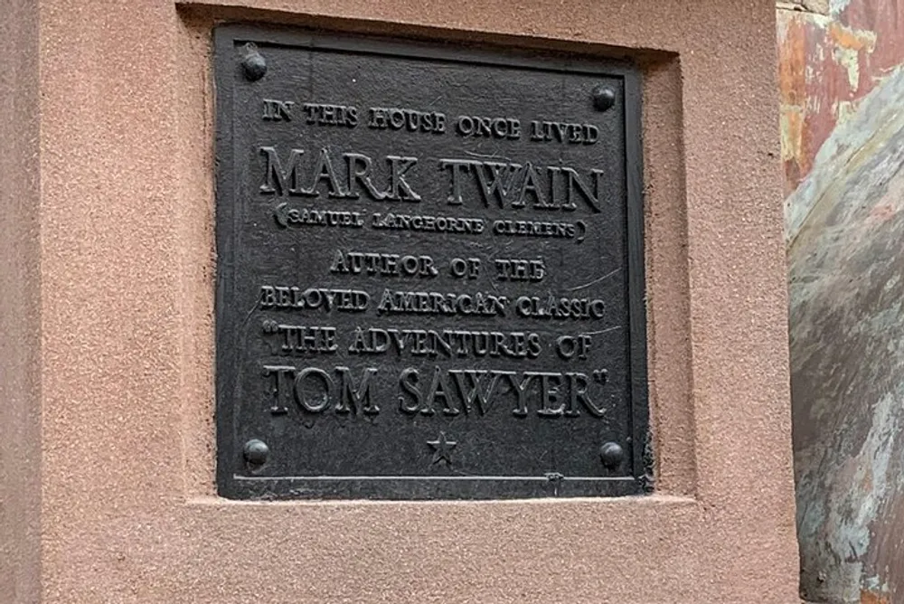 The image displays a commemorative plaque indicating that Mark Twain author of The Adventures of Tom Sawyer once lived in this house