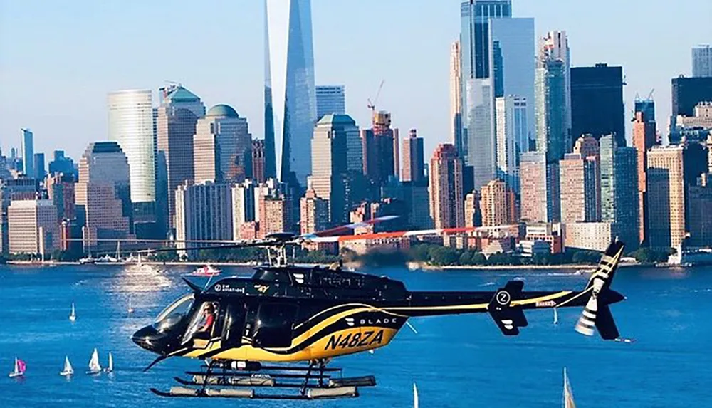 A helicopter is flying over a body of water with a dense urban skyline in the background
