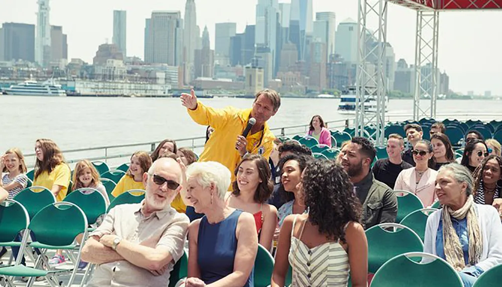 A group of people some wearing matching yellow jackets are enjoying a sightseeing tour on a boat with a city skyline in the background