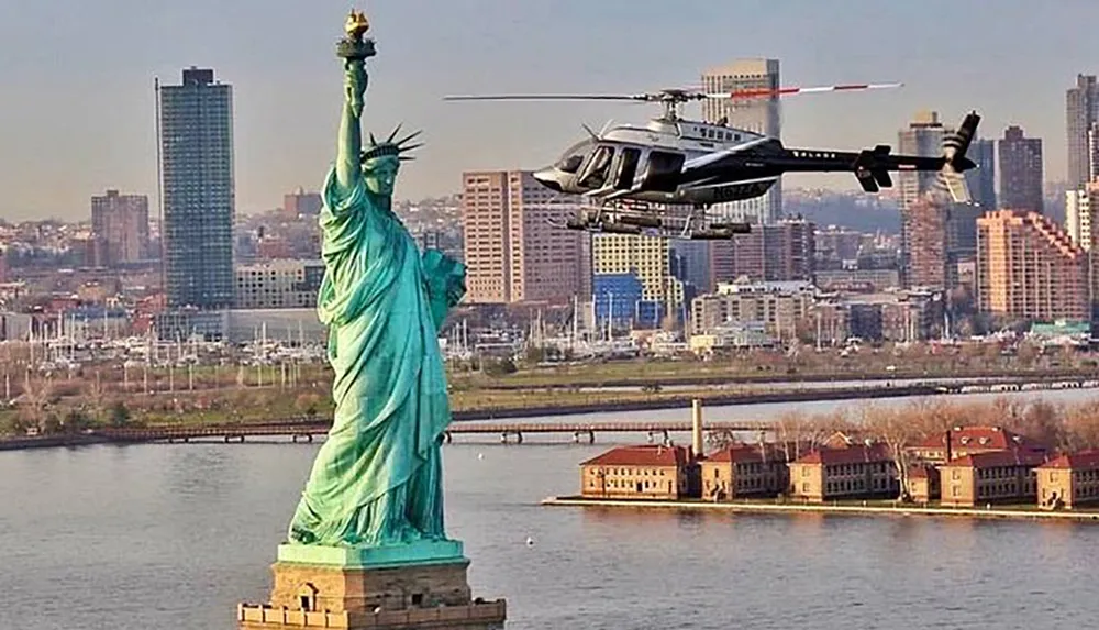 A helicopter is flying near the Statue of Liberty with a cityscape in the background