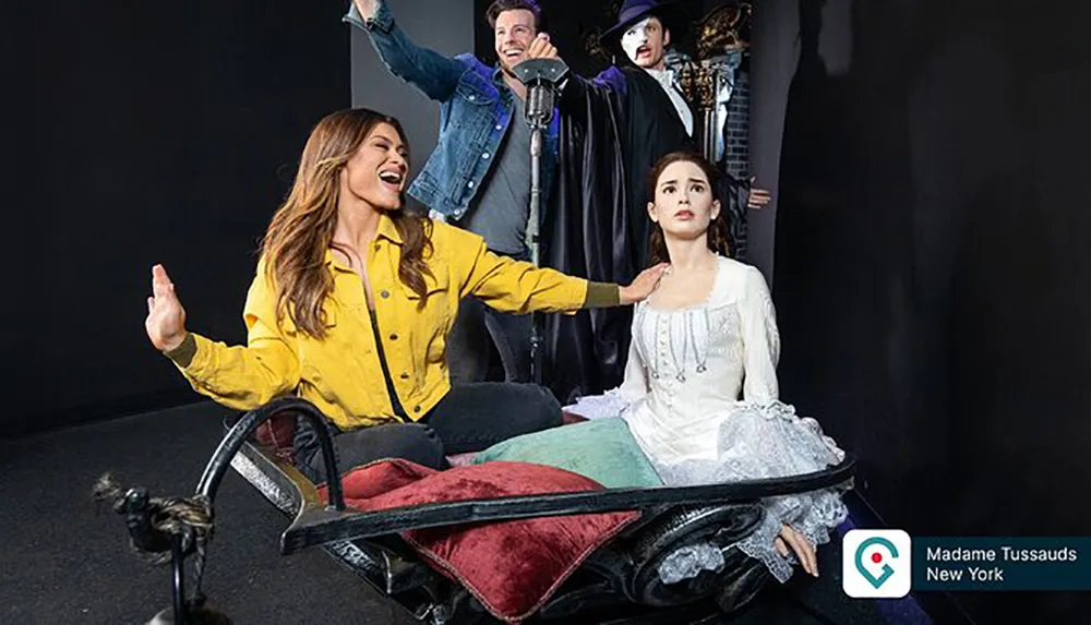 A person is posing and laughing with wax figures in a staged setting at Madame Tussauds New York