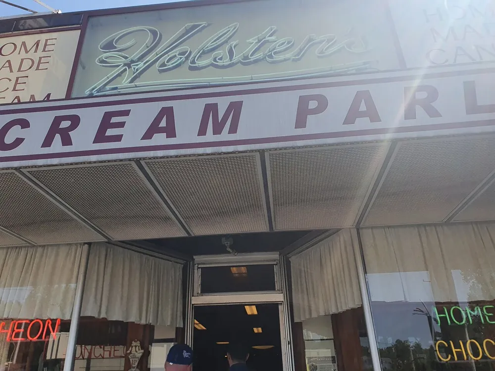 The image shows the entrance to Holstens an ice cream parlor with signage that includes words like Homemade Ice Cream and Home Made Chocolates suggesting an establishment that offers desserts and sweets