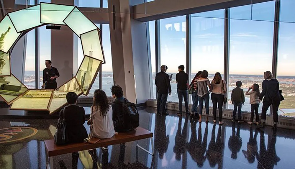 Visitors are enjoying the view from an observation deck near an artistic structure while a guide explains features of the vista
