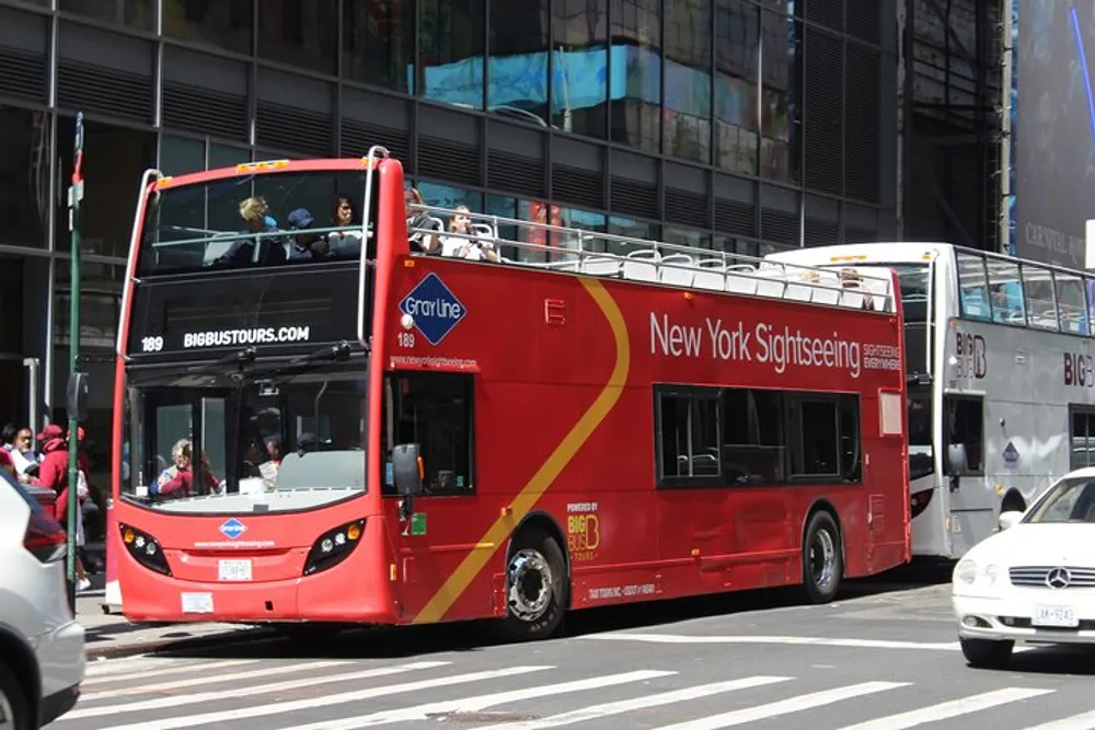 A red double-decker sightseeing tour bus is navigating through a busy urban street