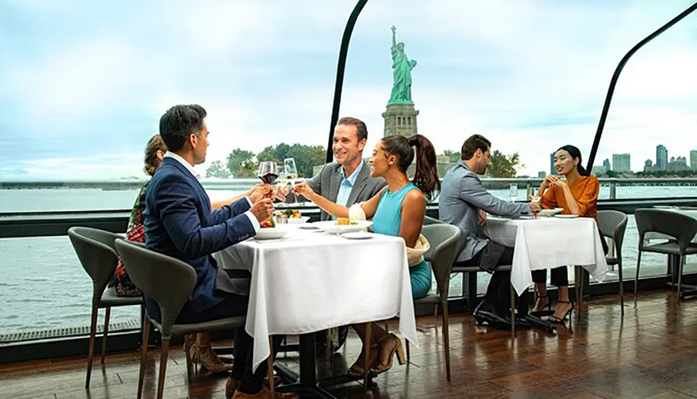 People are dining on a boat with a view of the Statue of Liberty