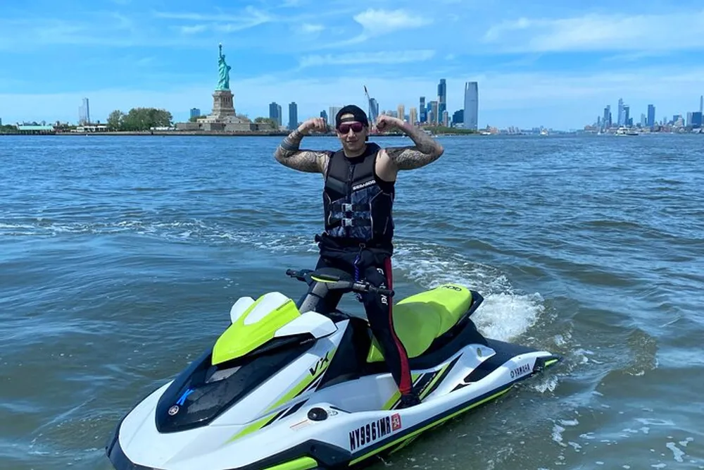 A person is posing on a jet ski in a body of water with the Statue of Liberty and the New York City skyline in the background