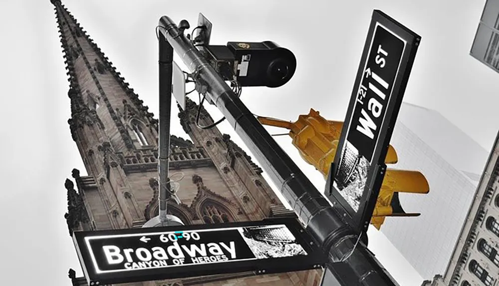 The image features a street sign at the intersection of Broadway and Wall Street in New York City adorned with the additional title Canyon of Heroes with a traffic signal and a gothic-style building in the background