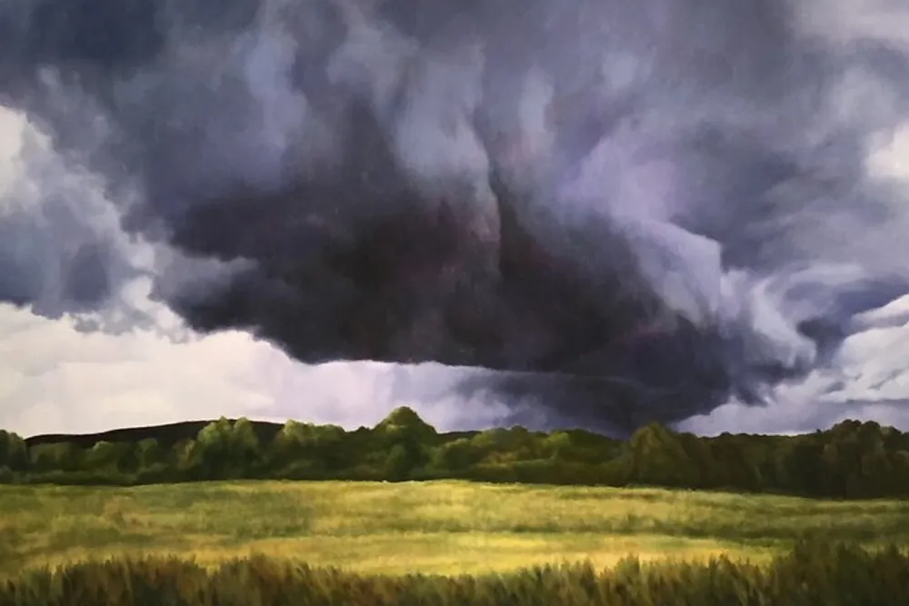 The image shows a dramatic landscape with a large ominous storm cloud looming over a serene green field with trees on the horizon