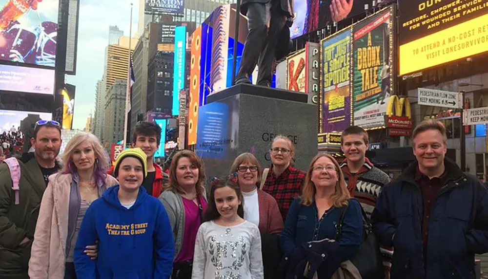 A group of people are posing for a photo in Times Square surrounded by bright billboards and city lights