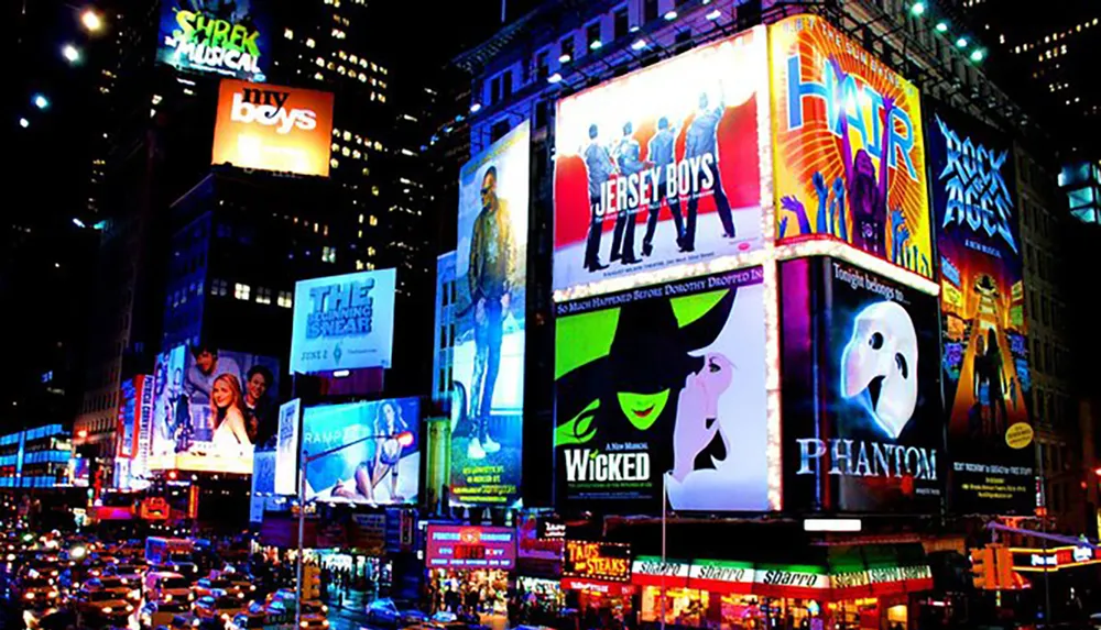 The image shows the vibrant and illuminated billboards of New York Citys Times Square at nighttime bustling with traffic and advertising Broadway shows