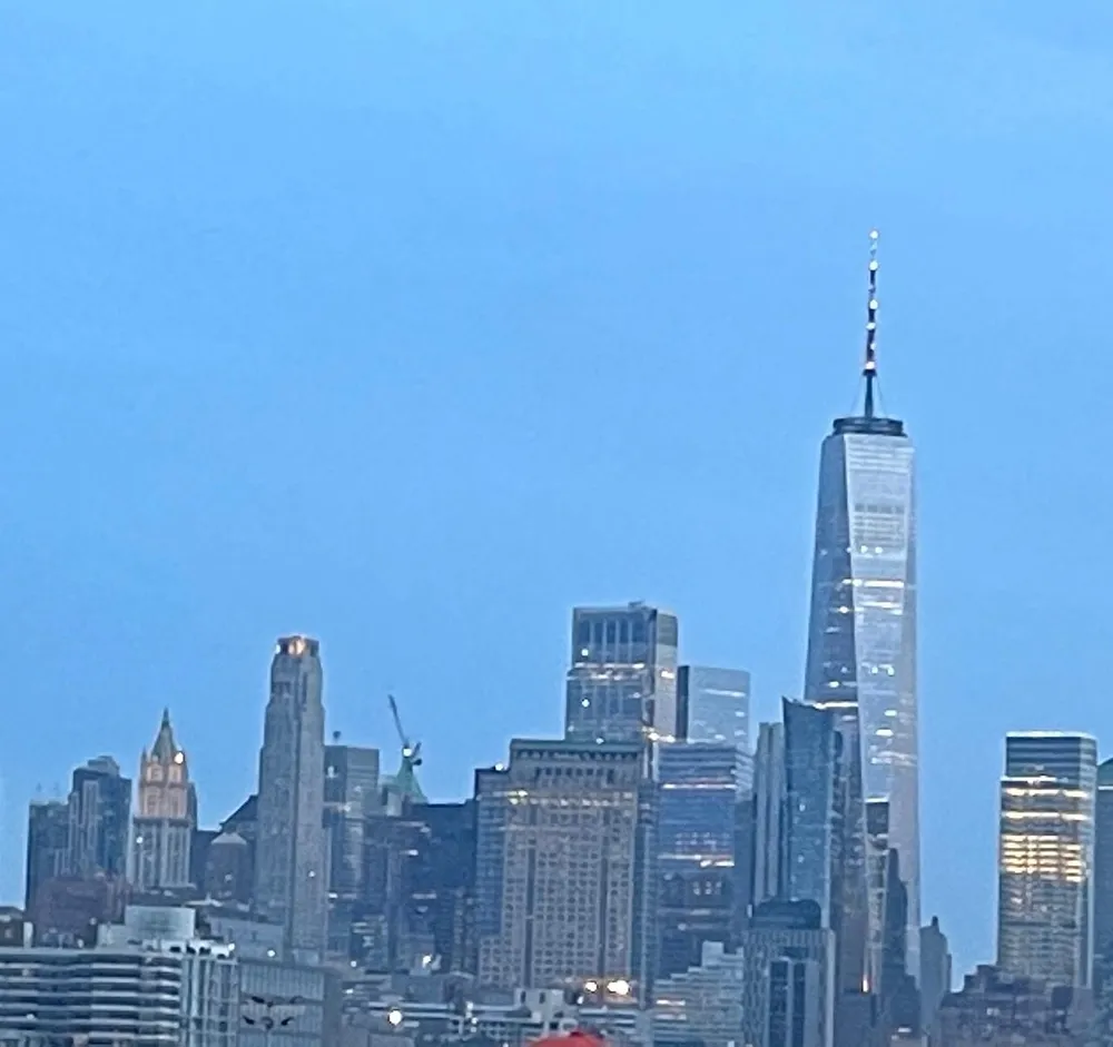 The image captures a skyline view featuring a prominent skyscraper bathed in the fading light of dusk