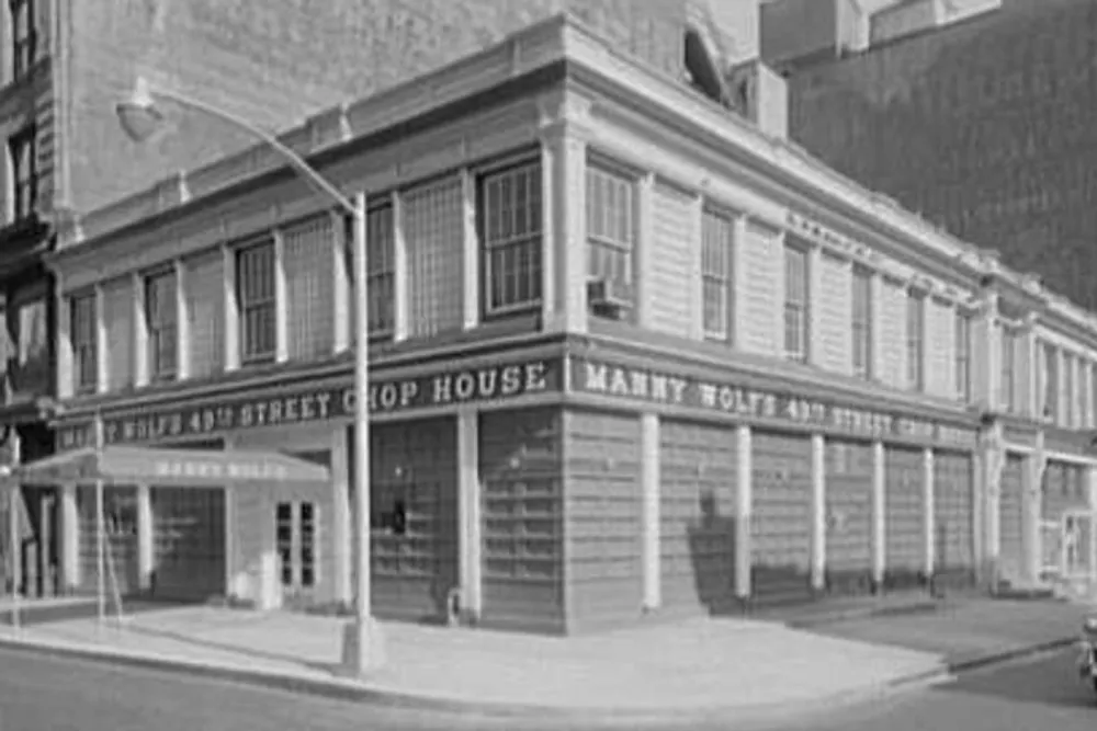 The image depicts a black-and-white photo of an old corner building with a sign for the 418 Street Chop House likely from an earlier part of the 20th century