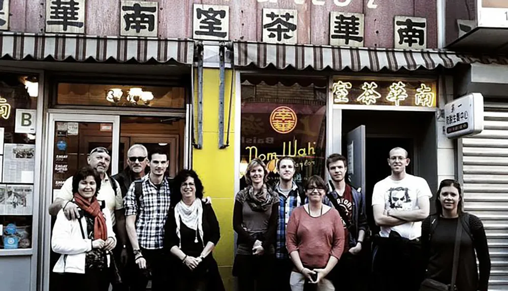A group of people are posing for a photo in front of an establishment with Chinese characters on its faade