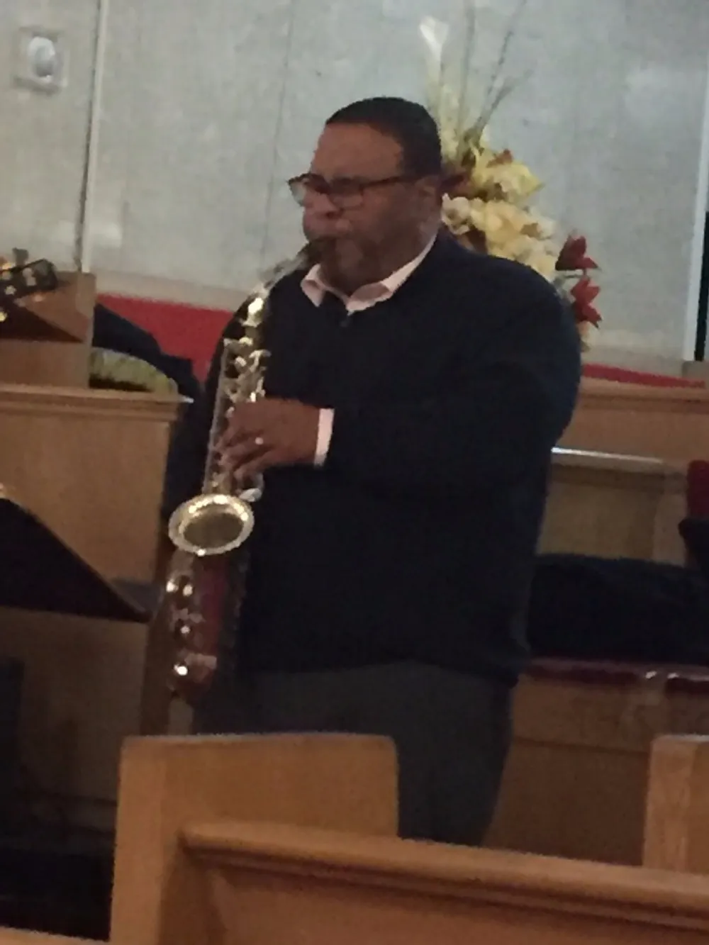A musician is playing a saxophone inside a church
