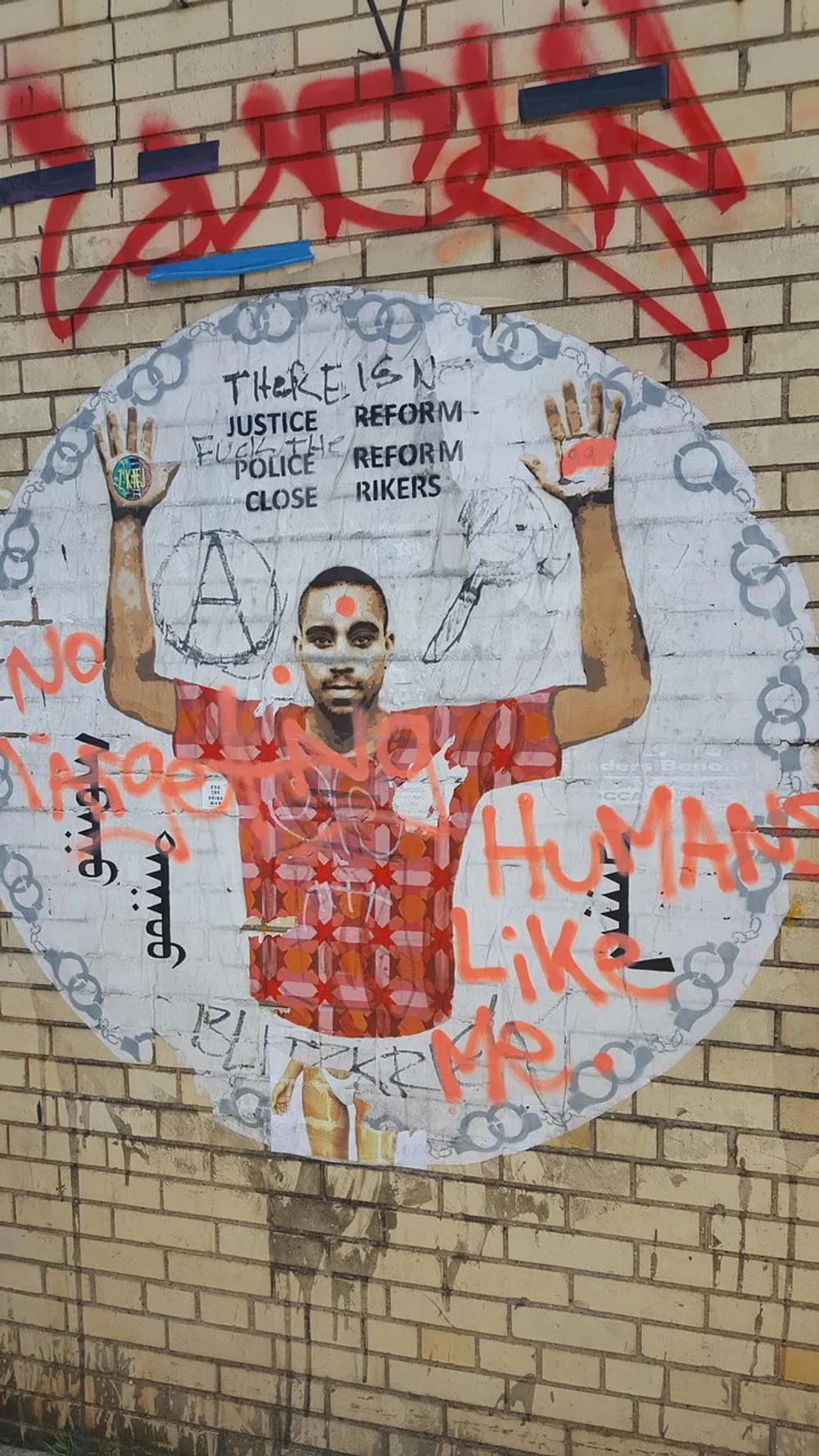 The image shows a piece of urban street art of a person with text and graphic elements advocating for justice reform and the closure of Rikers further emblazoned with graffiti marks