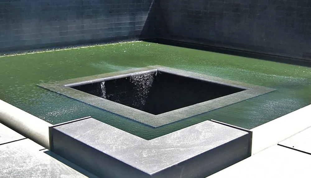 The image shows a modern water feature with cascading geometric pools designed in a minimalist style