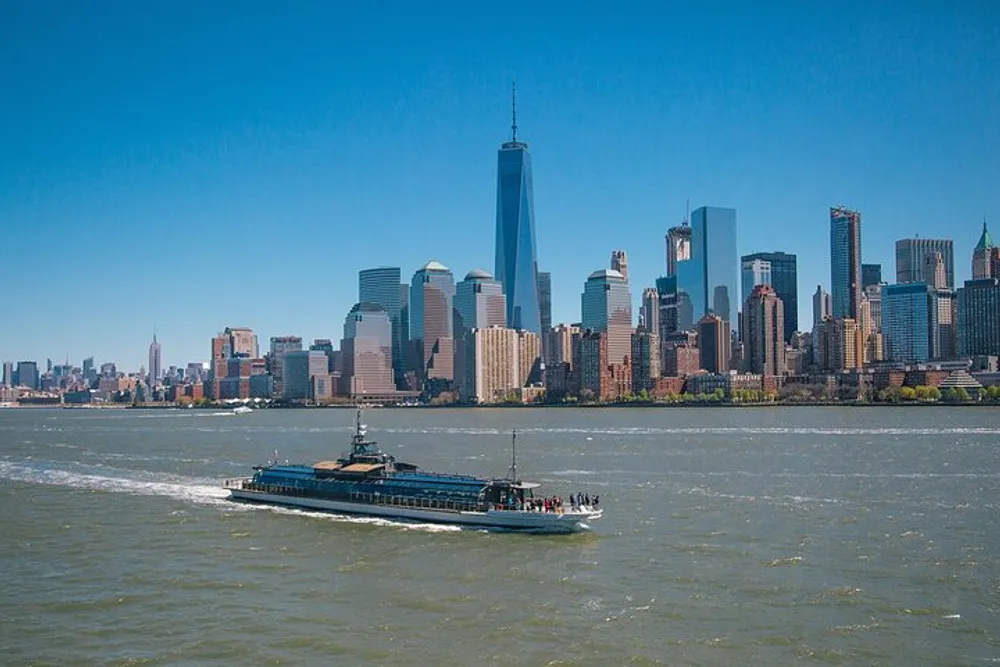 A ferry boat is cruising in front of the skyline of Lower Manhattan on a clear day