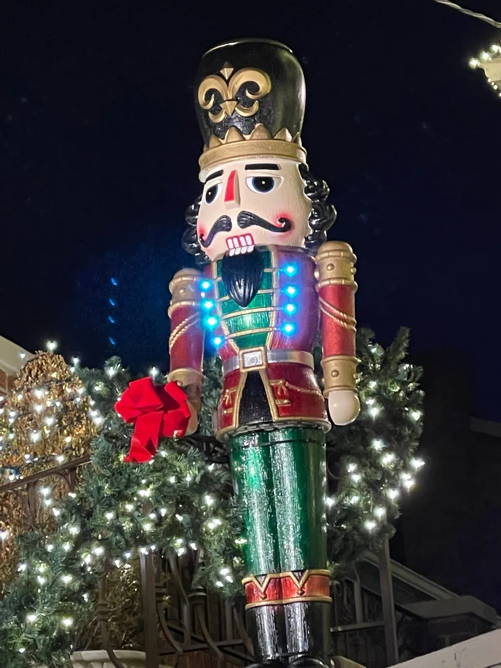 The image shows a large illuminated nutcracker decoration surrounded by festive lights likely part of a holiday display
