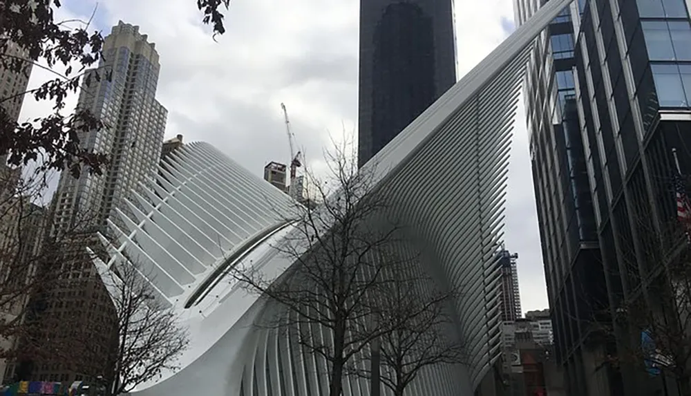 The image shows the distinctive modern architecture of the Oculus transportation hub at the World Trade Center site surrounded by high-rise buildings in New York City