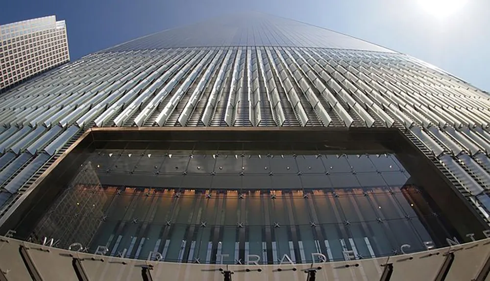 The image shows a low-angle view of a modern high-rise building with a sleek facade leading the eye towards the sky