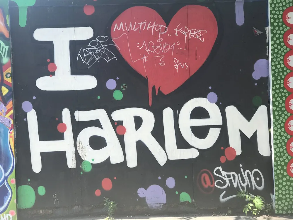 The image shows a colorful street art mural with the phrase I  HARLEM prominently displayed