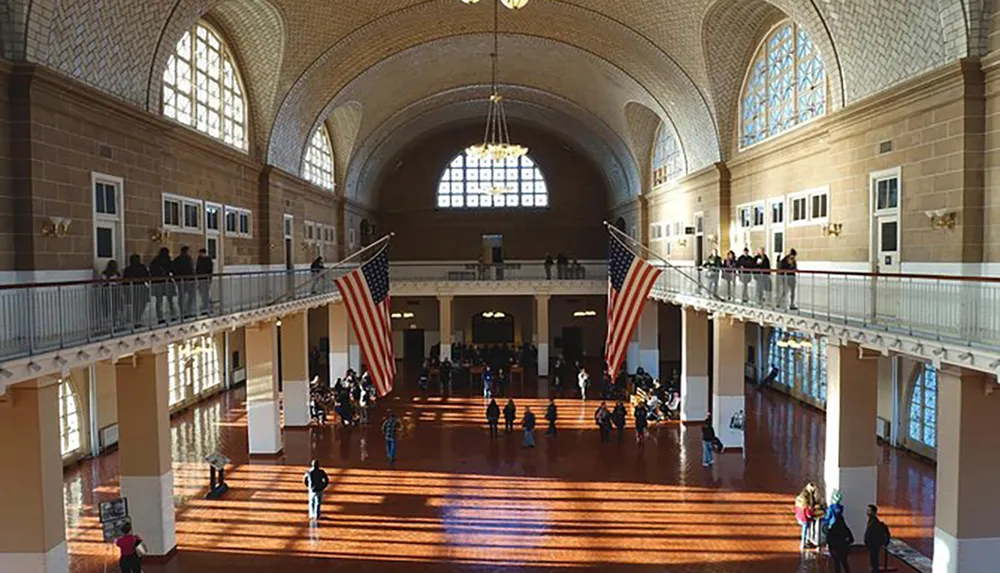 The image shows a large interior hall with arched windows a vaulted ceiling an American flag and people walking on the ground floor and balconies