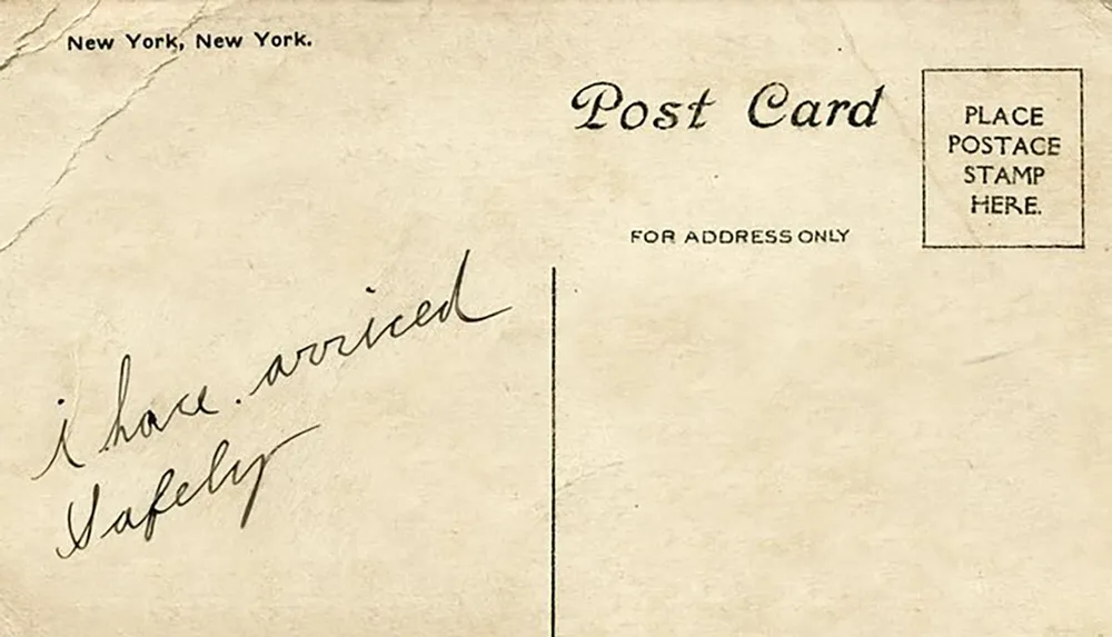 The image shows the back of an old postcard with a brief handwritten message stating i have arrived safely and a pre-printed designation for New York New York with separate spaces for address and postage stamp