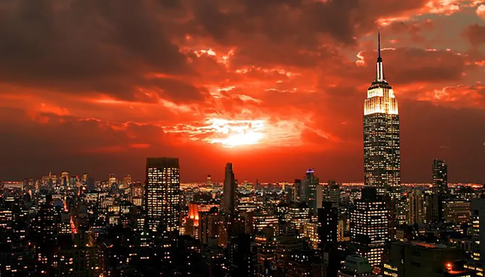 The image features a dramatic sunset illuminating the skyline with the Empire State Building prominently in the foreground against a moody sky