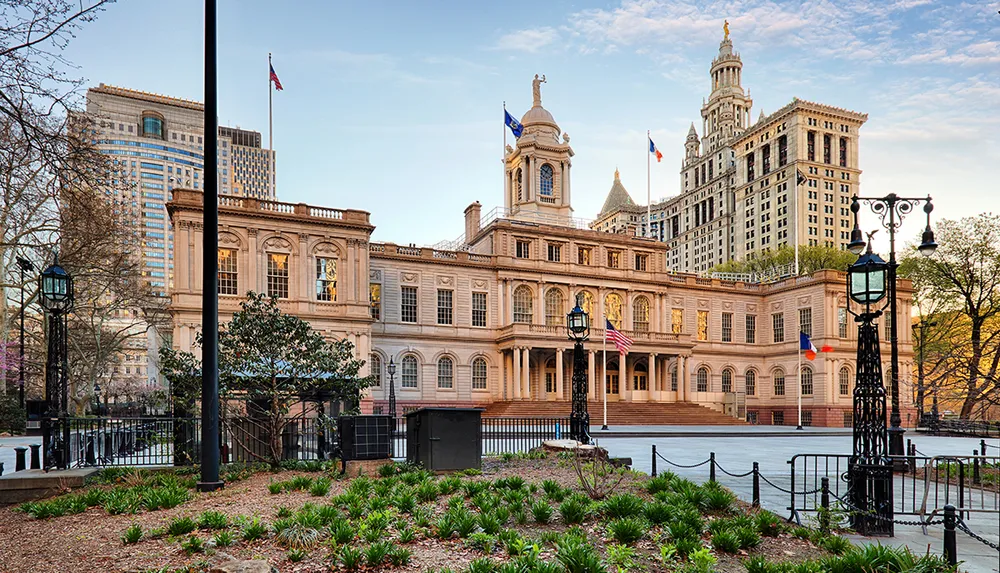 The image depicts City Hall the seat of New York Citys government with its classic architecture prominently featured amongst modern skyscrapers in the background