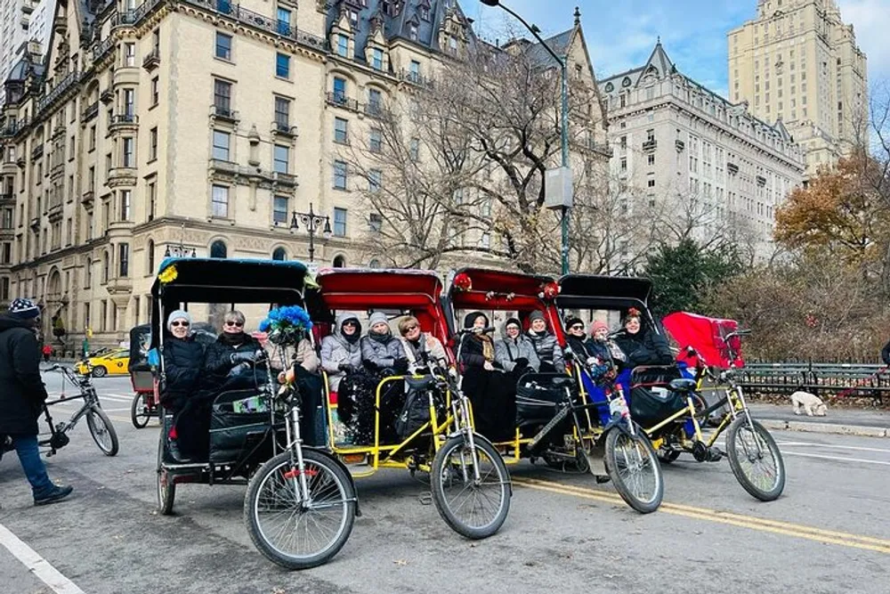 A group of people enjoys a pedal-powered rickshaw ride in an urban park setting with historic buildings in the background