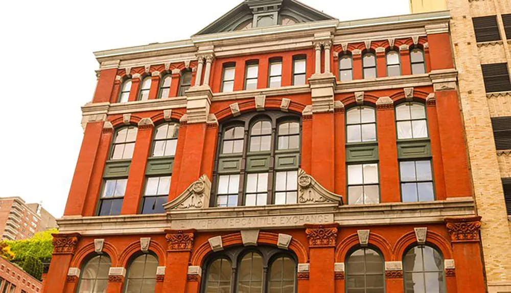 The image shows a historic red brick building with ornate detailing and arched windows labeled Mercantile Exchange