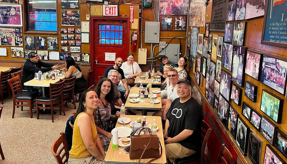A group of people is enjoying a meal together at a diner adorned with photographs on the wall