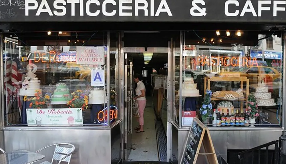 The image shows a person entering a traditional Italian pasticceria and caf adorned with cakes in the window display and signs indicating its open and has caf seating available