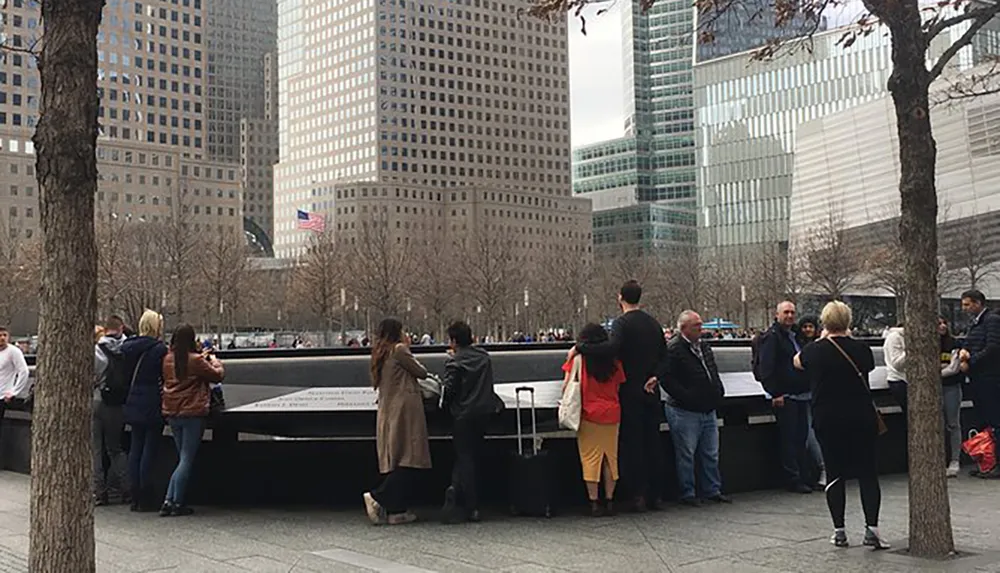 Visitors gather around one of the 911 Memorial pools in New York City set within the footprints of the original Twin Towers