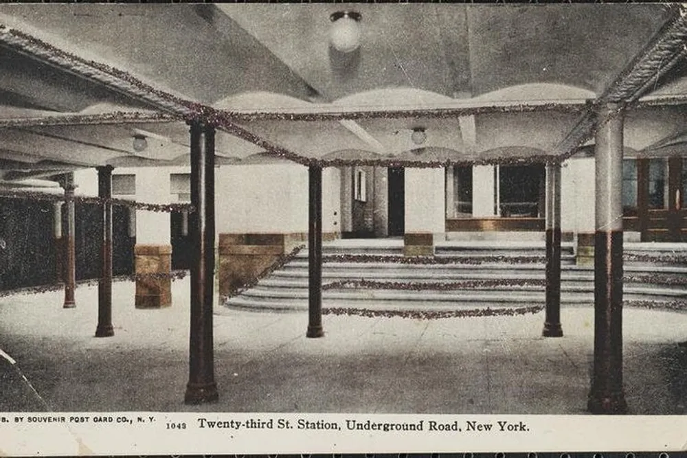 The image shows a vintage postcard of the 23rd Street Station on the Underground Road in New York displaying an interior view with columns benches and decorative details